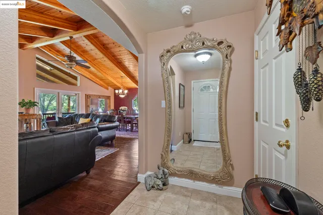 a living room with furniture a flat screen tv and a floor to ceiling window