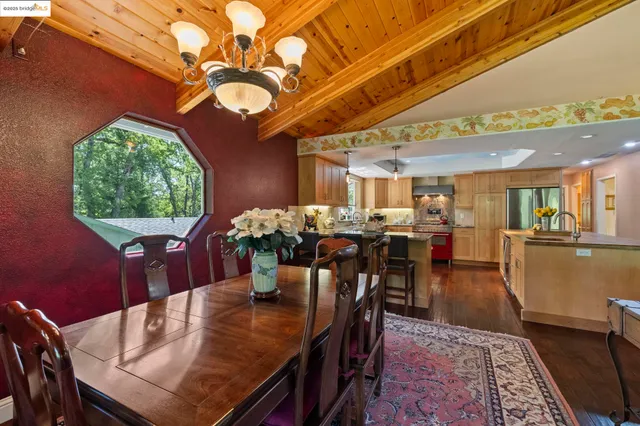 a view of a kitchen with kitchen island a large counter top space a sink stainless steel appliances and cabinets