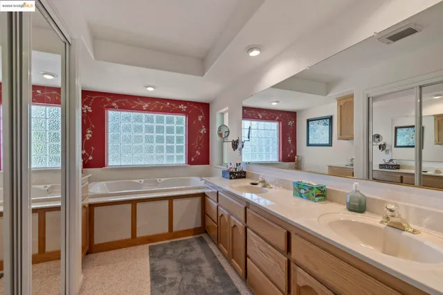 a bathroom with a granite countertop sink a mirror and shower