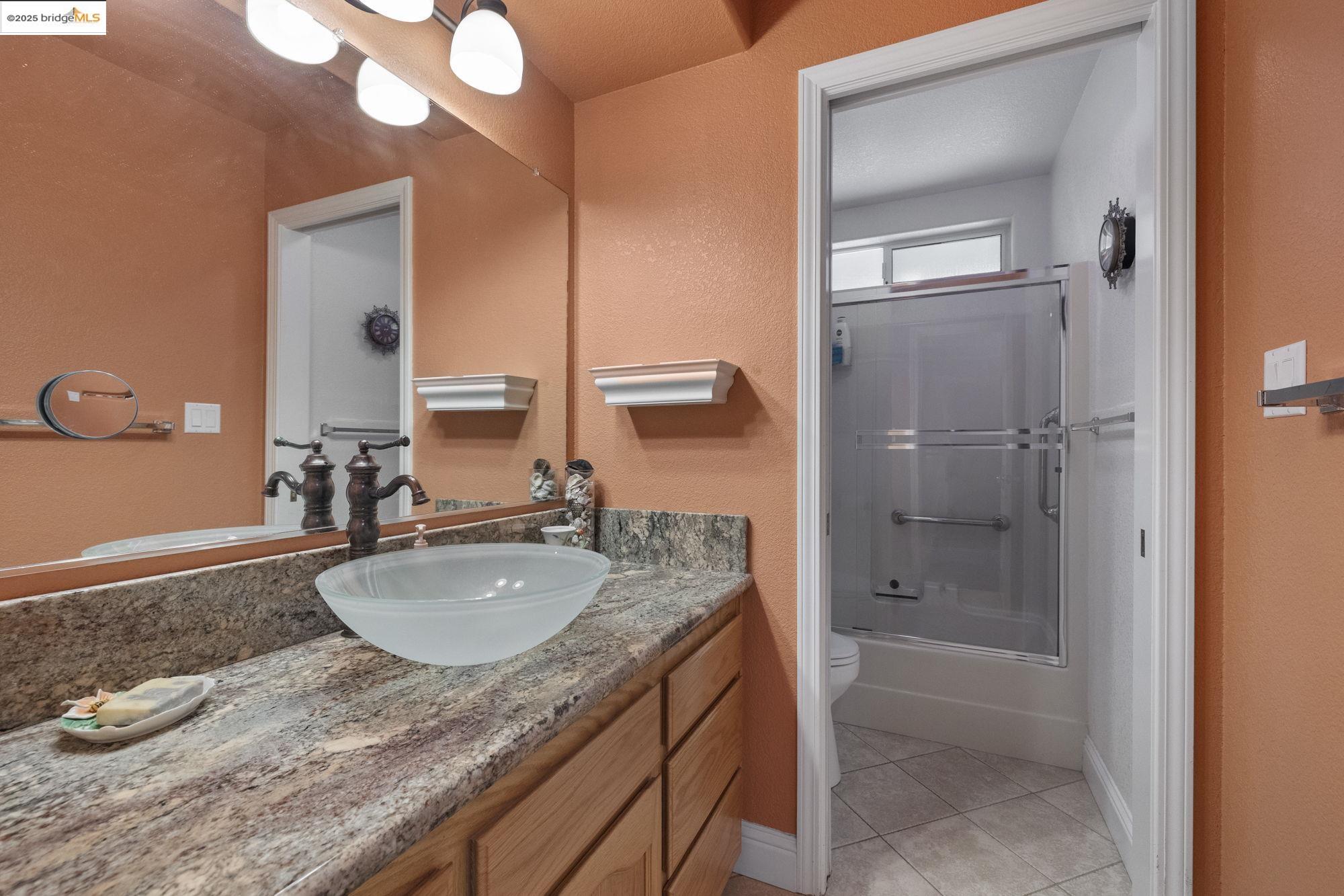 19400 Reid Circle Groveland, CA 95321 - Photo 44 of 60 a bathroom with a granite countertop sink a mirror and shower
