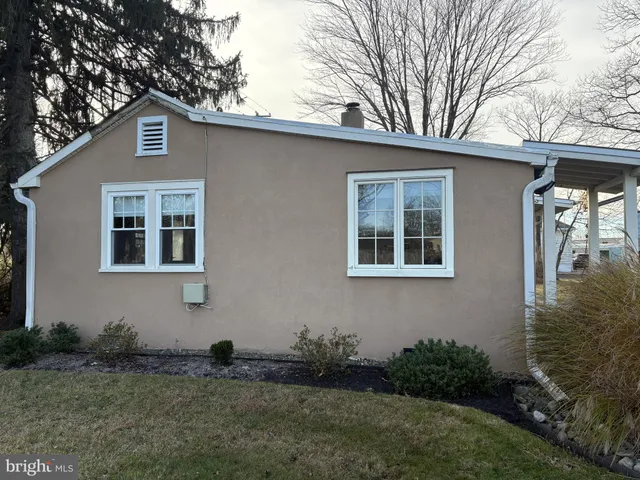 a front view of house with yard and trees in the background