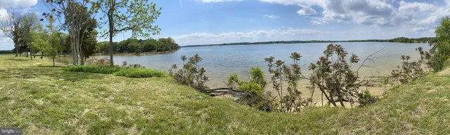 a view of a lake with green valley and mountain view