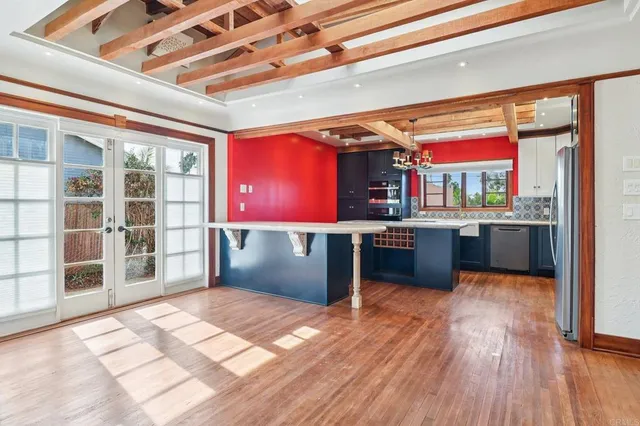 a room with stainless steel appliances kitchen island granite countertop a refrigerator a stove and a sink with dishwasher