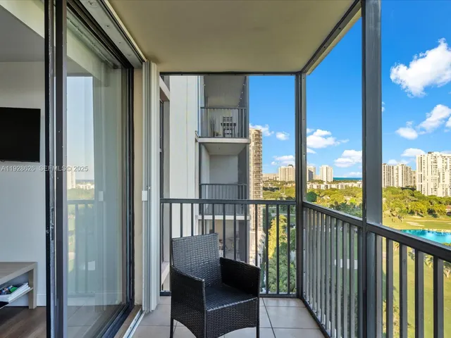 a view of a balcony with furniture and floor to ceiling window