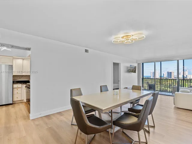 a view of a dining room with furniture a chandelier and wooden floor