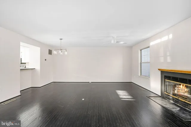 an empty room with wooden floor and a fireplace
