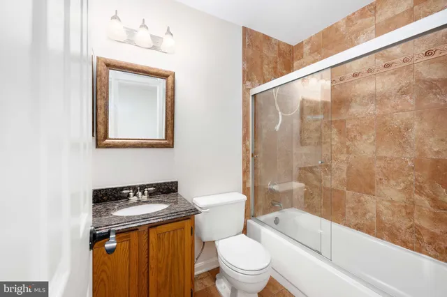 a bathroom with a granite countertop toilet a sink and bathtub