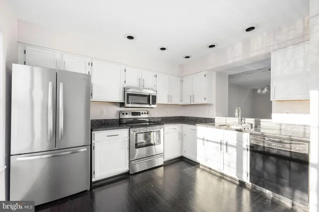 a kitchen with stainless steel appliances a refrigerator a stove top oven and sink