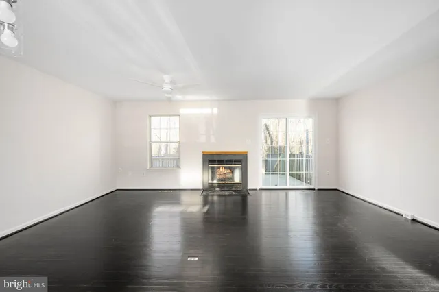 an empty room with wooden floor and a fireplace