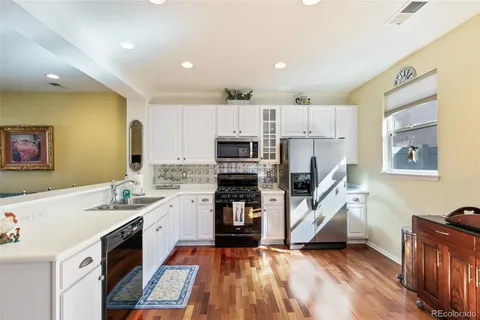a large kitchen with stainless steel appliances kitchen island granite countertop a refrigerator and a stove top oven
