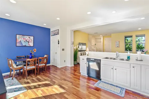 a living room with stainless steel appliances kitchen island granite countertop furniture and a wooden floor