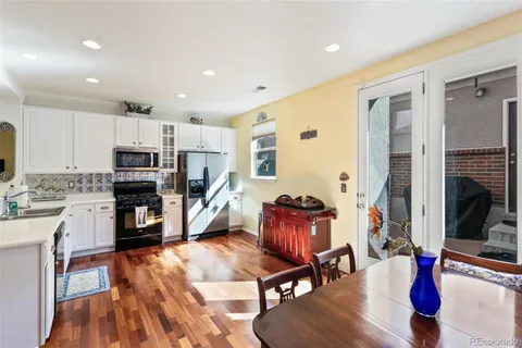 a living room with stainless steel appliances kitchen island granite countertop furniture and a wooden floor