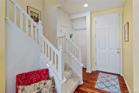 a view of a hallway with wooden floor and stairs