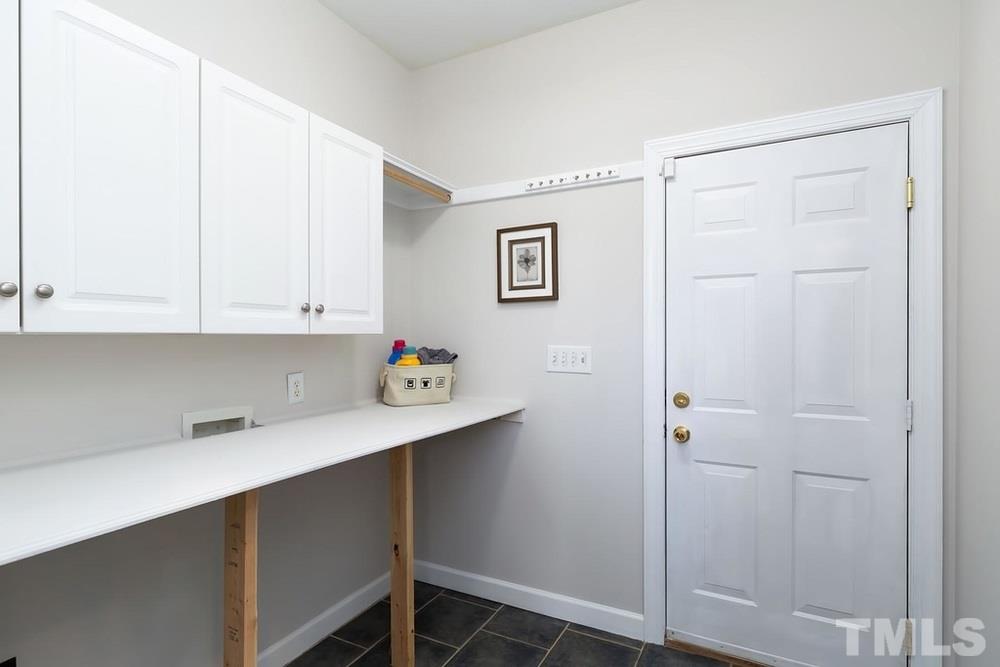 4401 Irene Way Raleigh, NC 27603 - Photo 11 of 30 Laundry Room with cabinet storage and folding table.