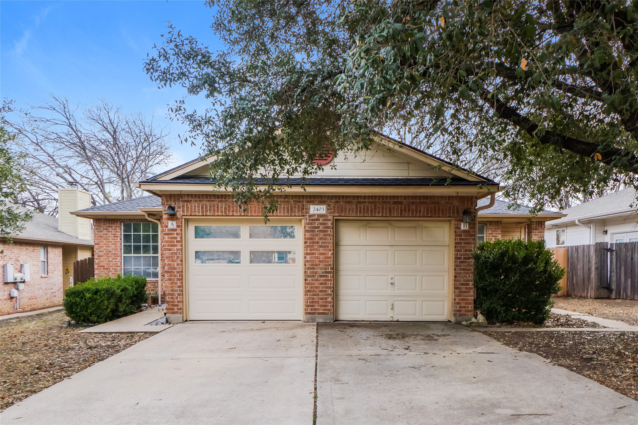 View of front of property featuring concrete driveway, an attached garage, and brick siding