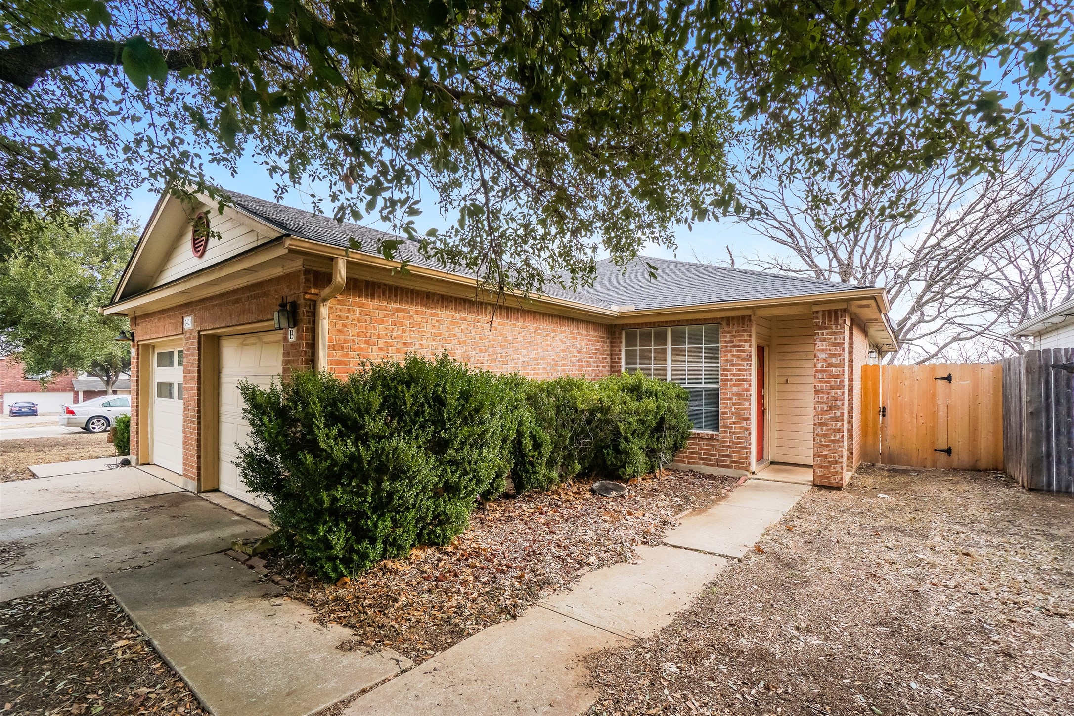 2403 Curry Loop Round Rock, TX 78664 - Photo 3 of 16 Ranch-style house with brick siding, roof with shingles, a garage, a gate, and concrete driveway