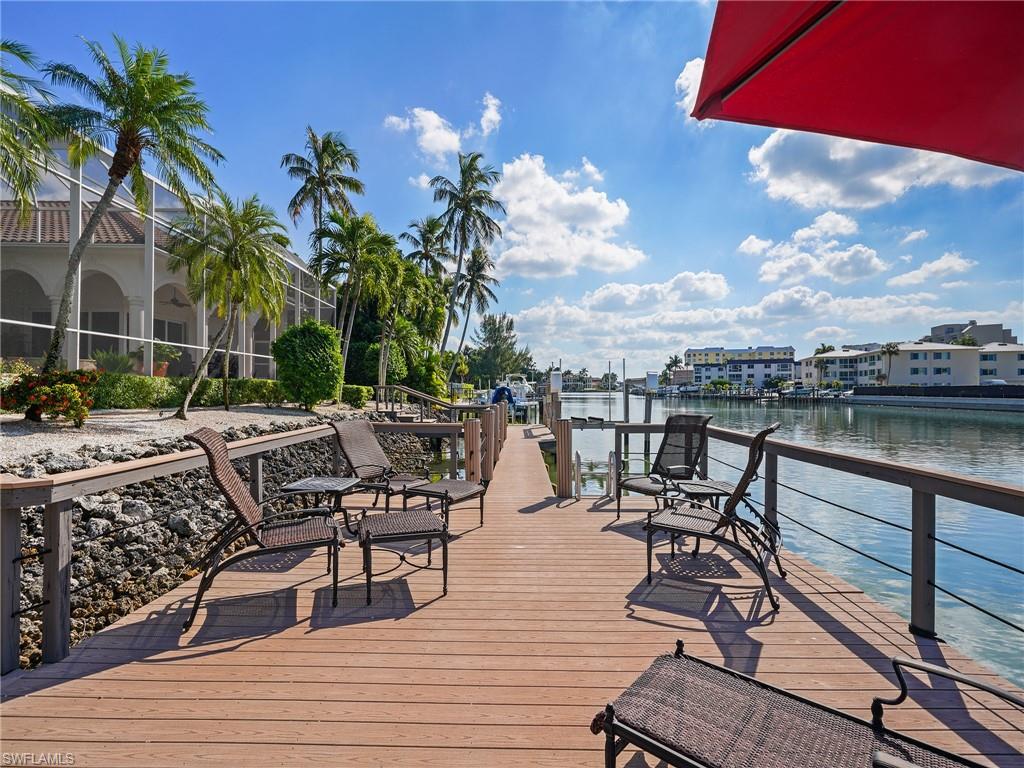 216 Springline Drive Naples, FL 34102 - Photo 12 of 46 Dock area featuring a deck with water view and a lanai