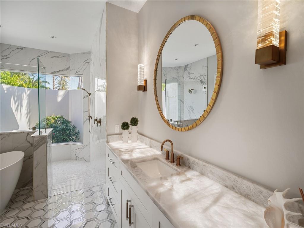216 Springline Drive Naples, FL 34102 - Photo 20 of 46 Full bathroom with vanity, a freestanding tub, and a marble finish shower