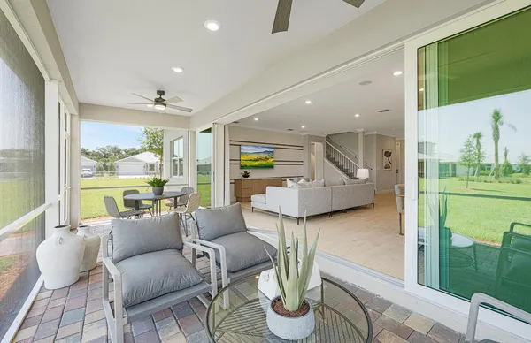 a living room with furniture a flat screen tv and kitchen view