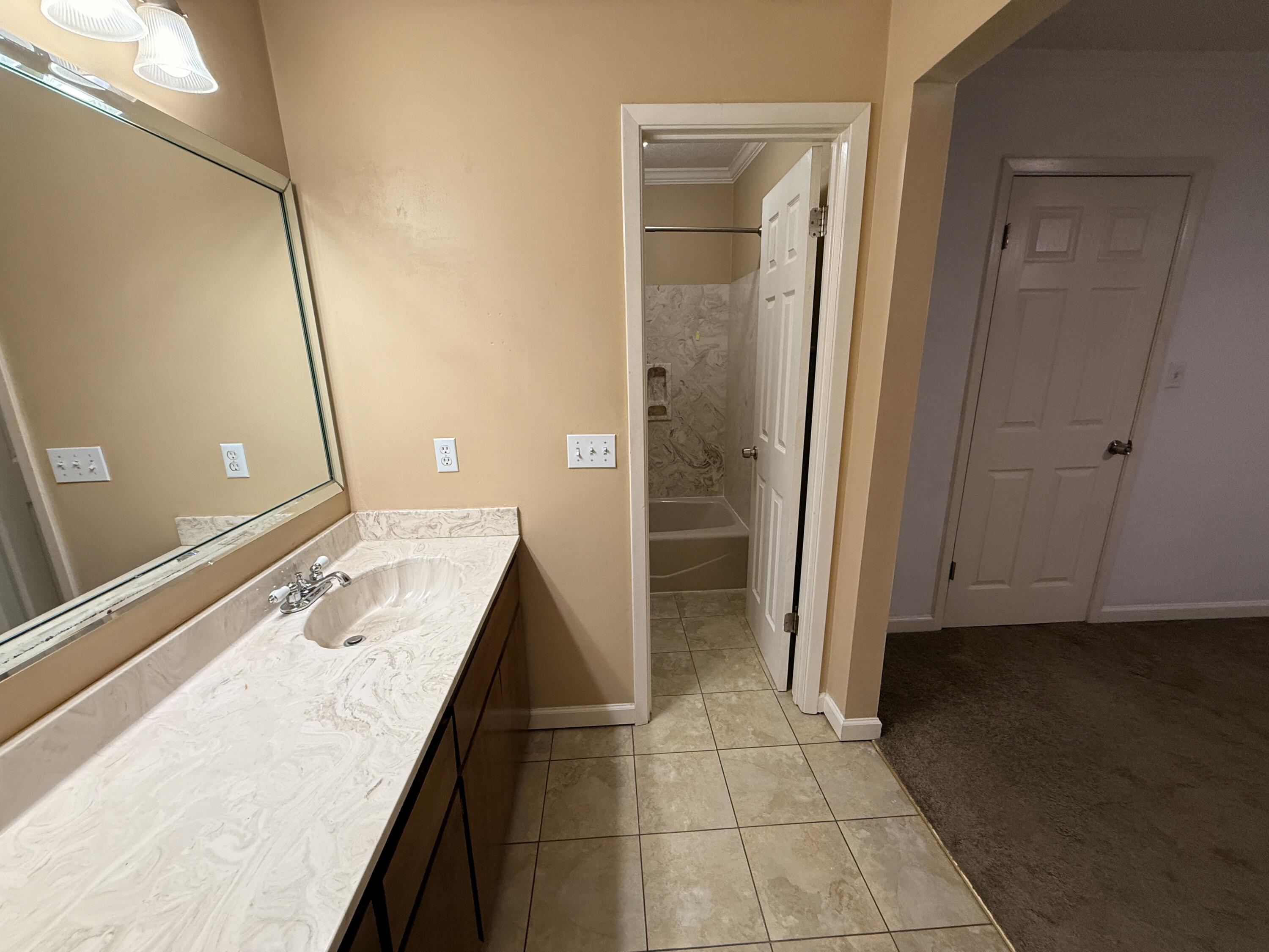 1054 9th Street Shalimar, FL 32579 - Photo 30 of 45 a bathroom with a granite countertop sink a mirror and a shower