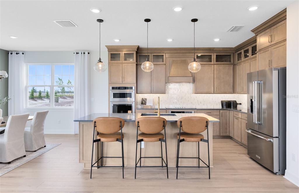 9821 Autumn Rdg Avenue Riverview, FL 33578 - Photo 2 of 30 a kitchen with a table chairs refrigerator and microwave
