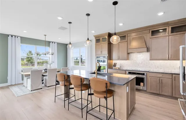 a kitchen with granite countertop a sink cabinets and stainless steel appliances