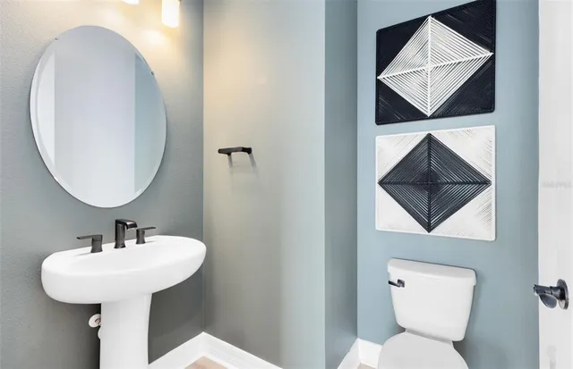 a bathroom with a toilet a sink and a mirror