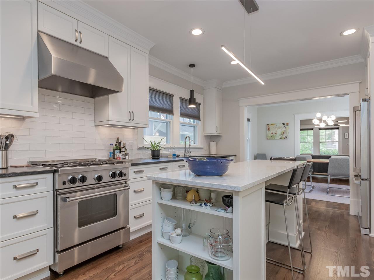 2215 The Circle Raleigh, NC 27608 - Photo 11 of 30 a kitchen with stainless steel appliances a stove a sink dishwasher and cabinets with wooden floor