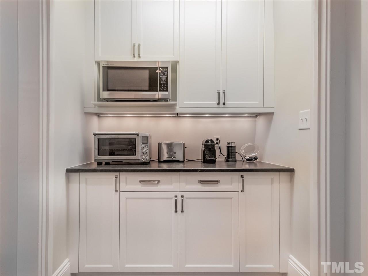 2215 The Circle Raleigh, NC 27608 - Photo 12 of 30 a kitchen with white cabinets and appliances