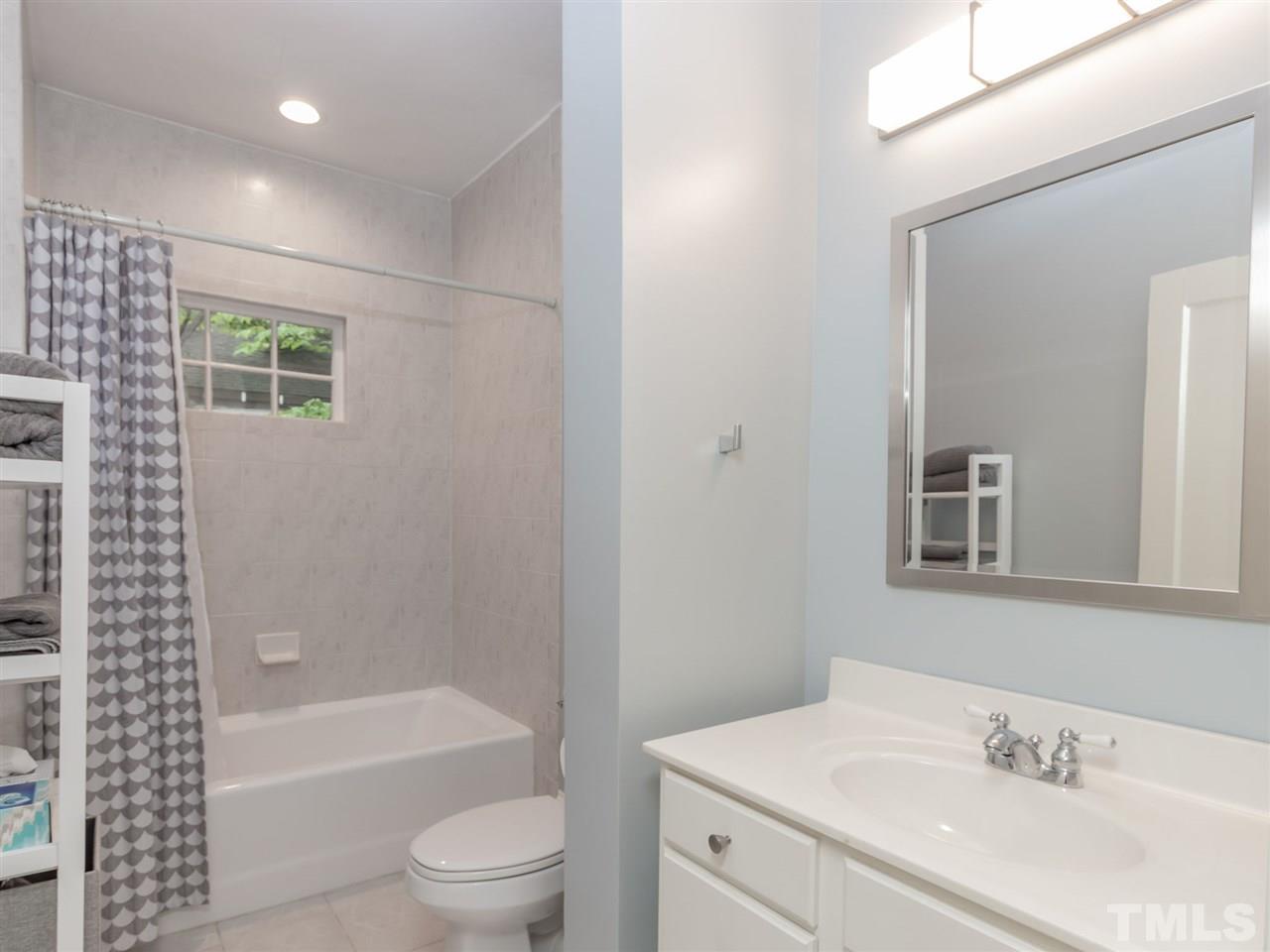 2215 The Circle Raleigh, NC 27608 - Photo 25 of 30 a bathroom with a bathtub shower sink vanity mirror and toilet