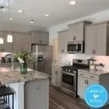 a kitchen with granite countertop a stove sink and refrigerator