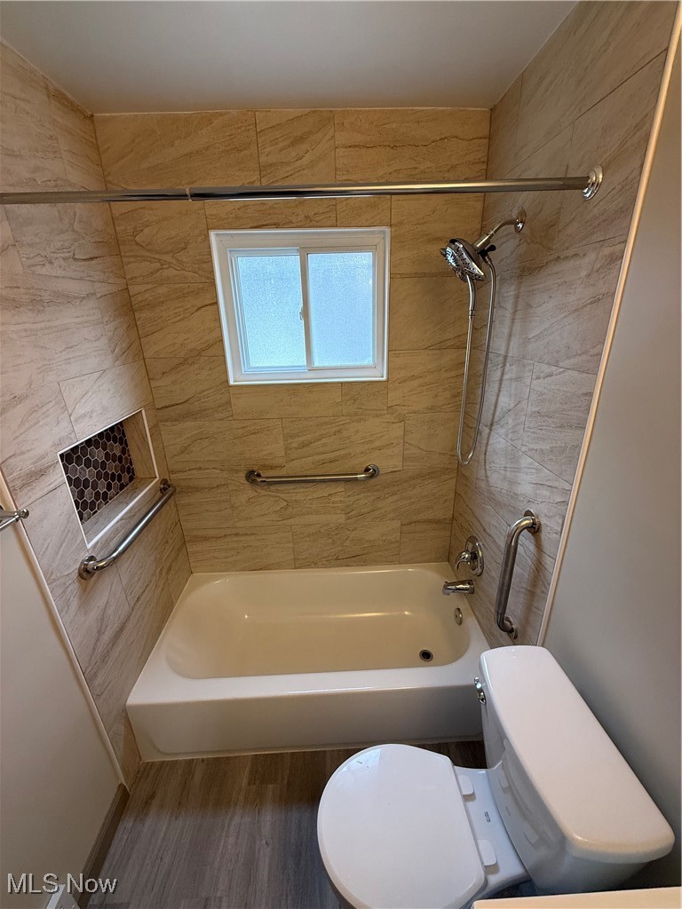 9417 Alexander Road Garfield Heights, OH 44125 - Photo 26 of 38 Bathroom featuring shower / bath combination, toilet, and wood finished floors