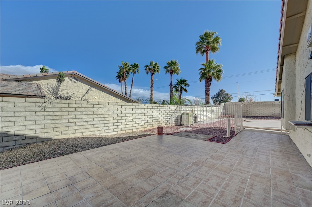 6635 Costa Brava Road Las Vegas, NV 89146 - Photo 49 of 59 A private, tiled patio space with lush palm trees offers an inviting outdoor retreat.