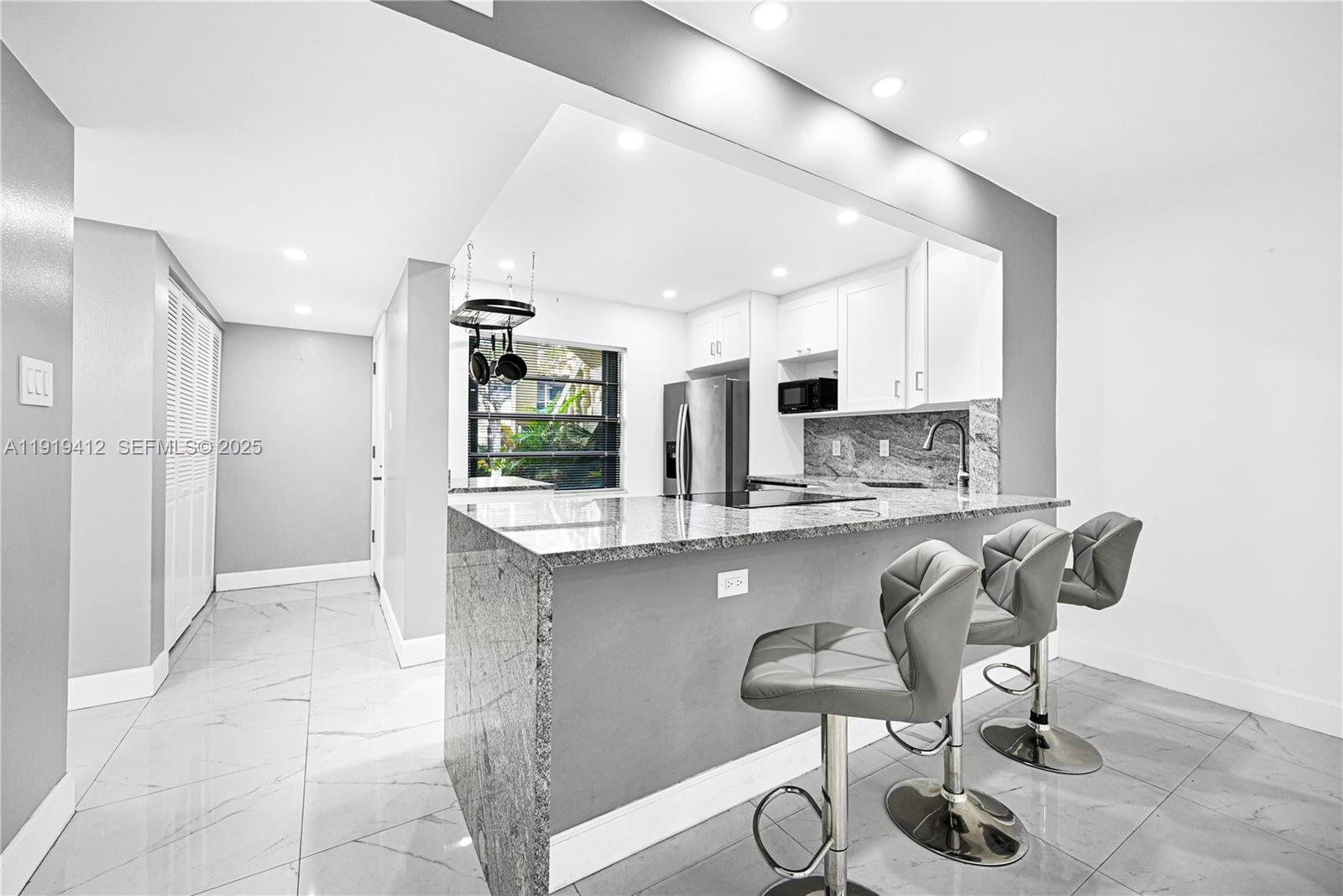 a kitchen with stainless steel appliances granite countertop a sink and a refrigerator