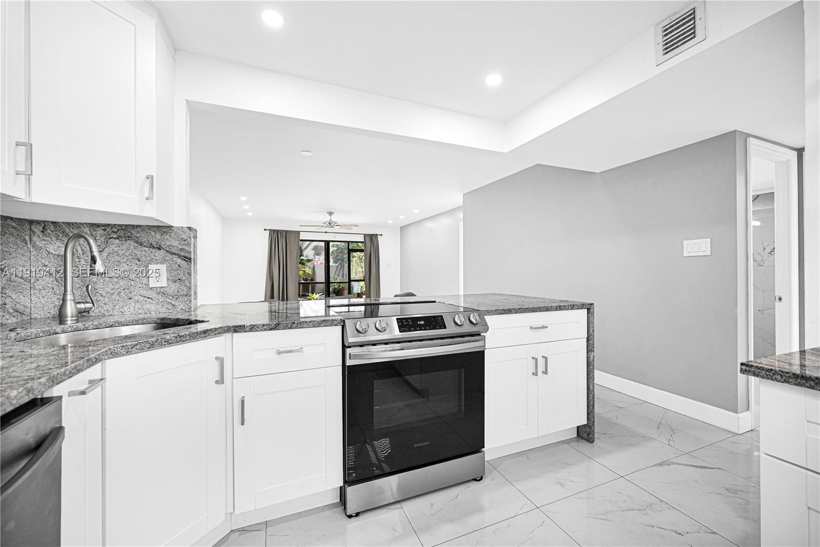 132 South Cypress Road, Unit 518 Pompano Beach, FL 33060 - Photo 11 of 60 a kitchen with a stove top oven sink and cabinets