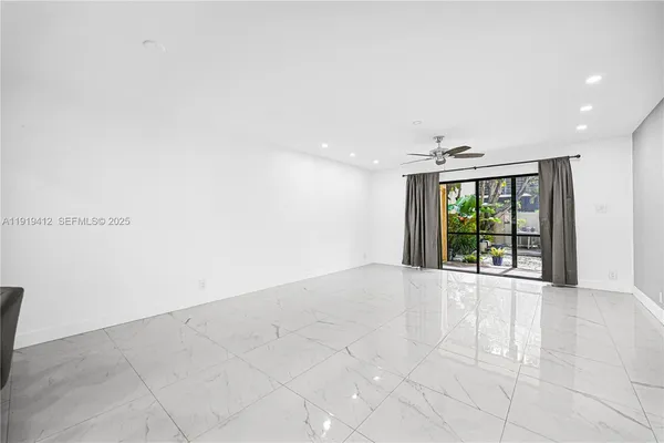 a view of a hallway with wooden floor and a window