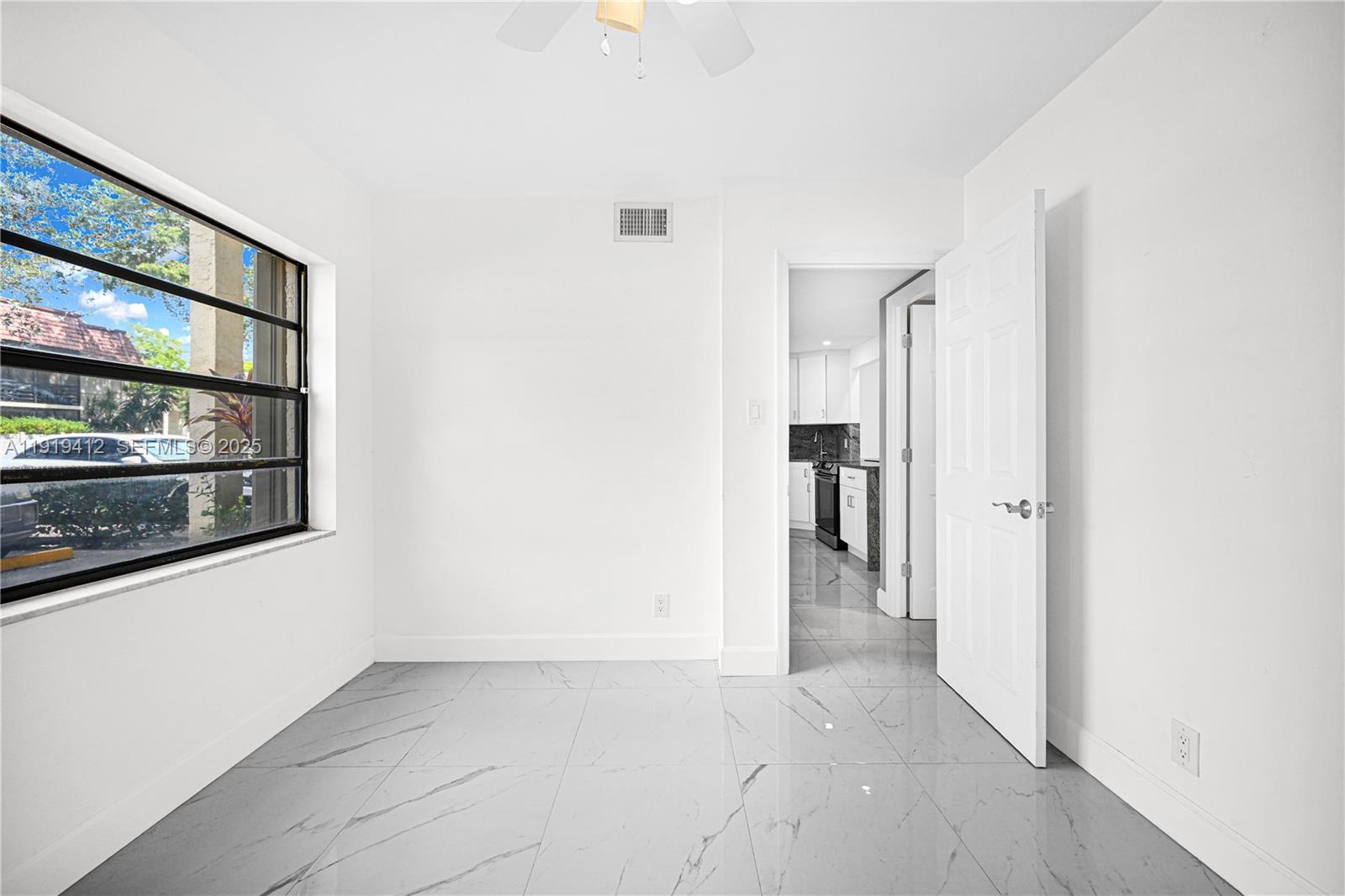 132 South Cypress Road, Unit 518 Pompano Beach, FL 33060 - Photo 15 of 60 a view of a hallway with wooden floor and a window
