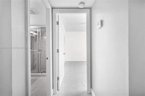 an empty room with windows and ceiling fan