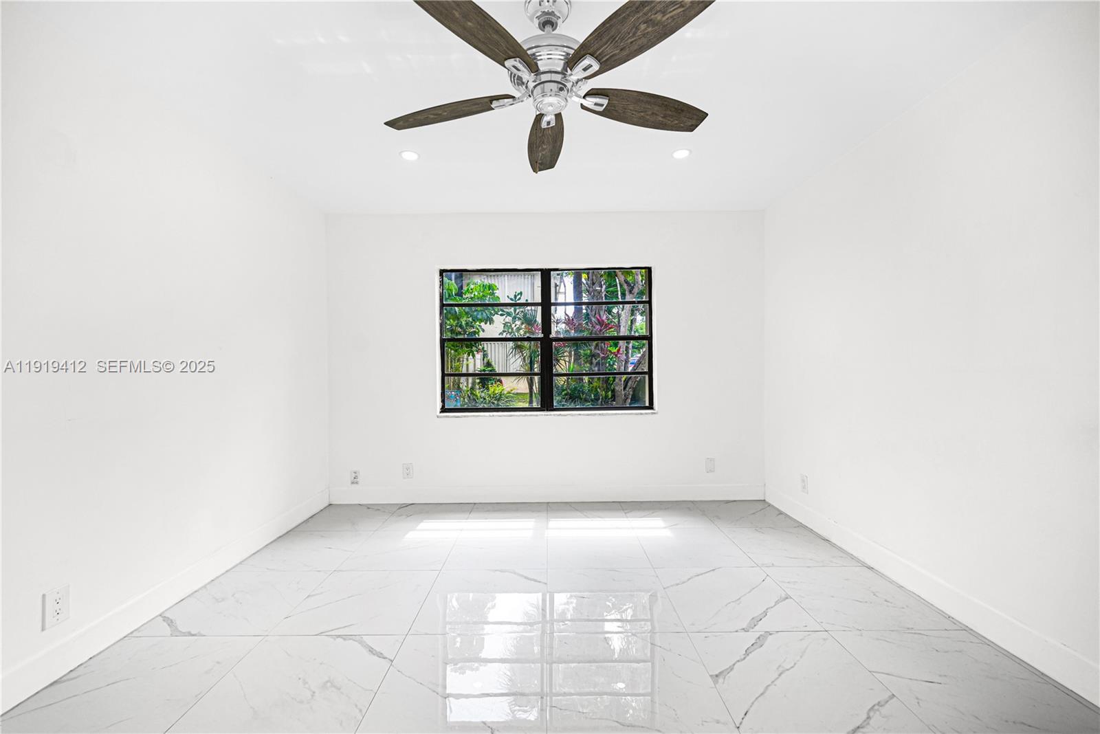 132 South Cypress Road, Unit 518 Pompano Beach, FL 33060 - Photo 22 of 60 an empty room with a window and a ceiling fan