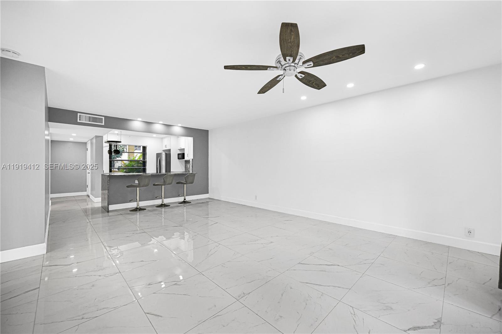 132 South Cypress Road, Unit 518 Pompano Beach, FL 33060 - Photo 30 of 60 a view of empty room with wooden floor and ceiling fan