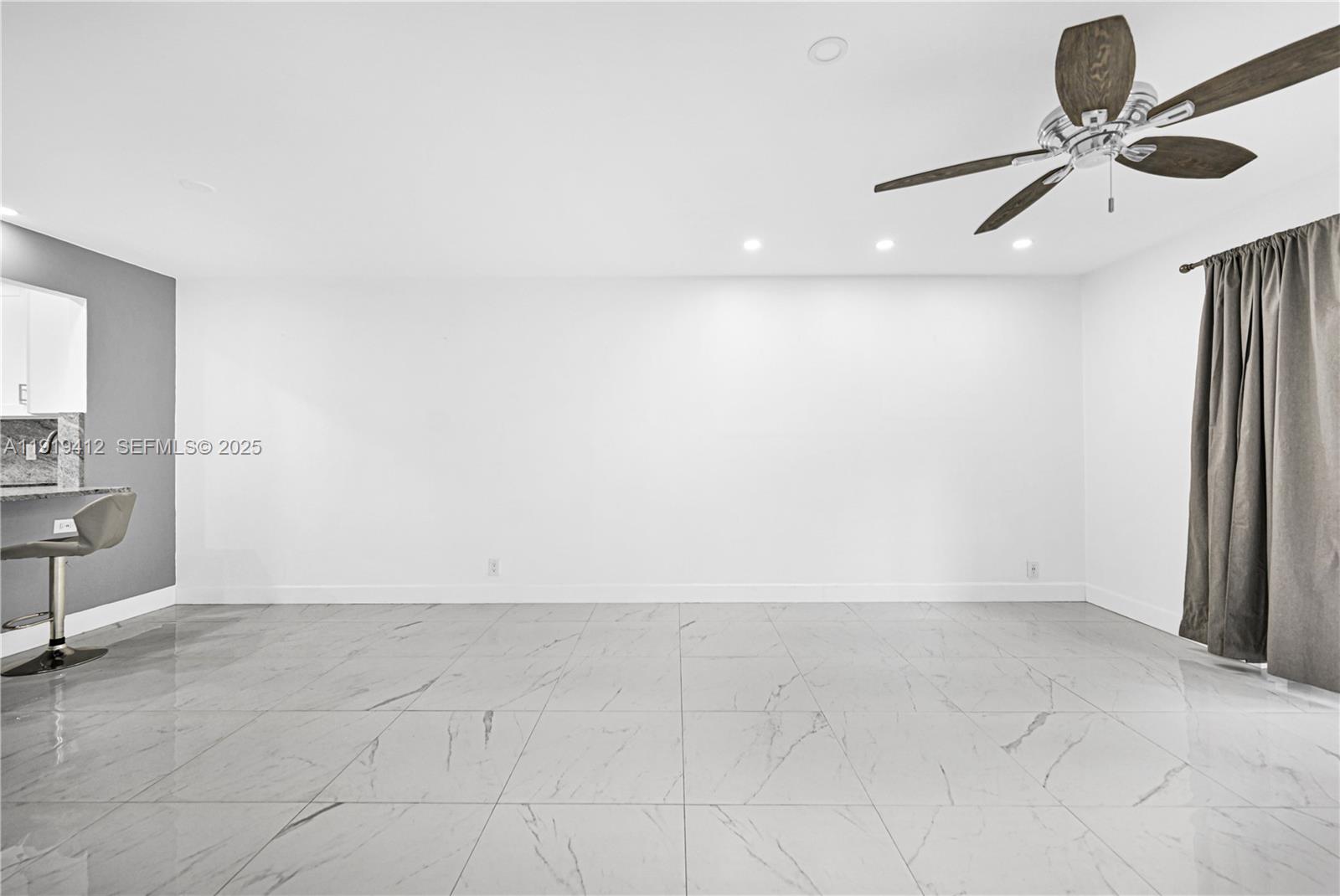 132 South Cypress Road, Unit 518 Pompano Beach, FL 33060 - Photo 5 of 60 an empty room with a ceiling fan and carpet