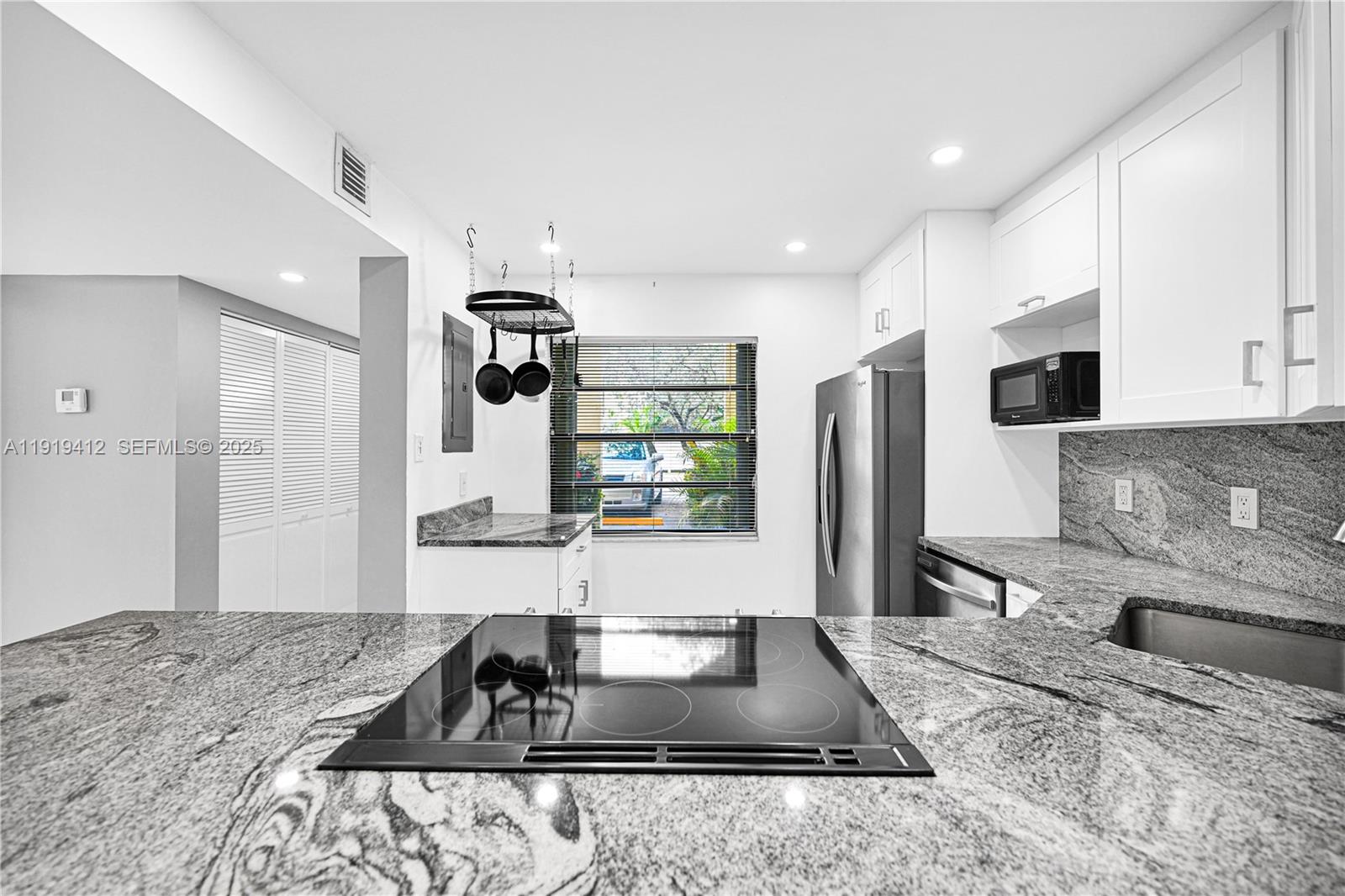 132 South Cypress Road, Unit 518 Pompano Beach, FL 33060 - Photo 6 of 60 a kitchen with granite countertop a sink a stove and refrigerator