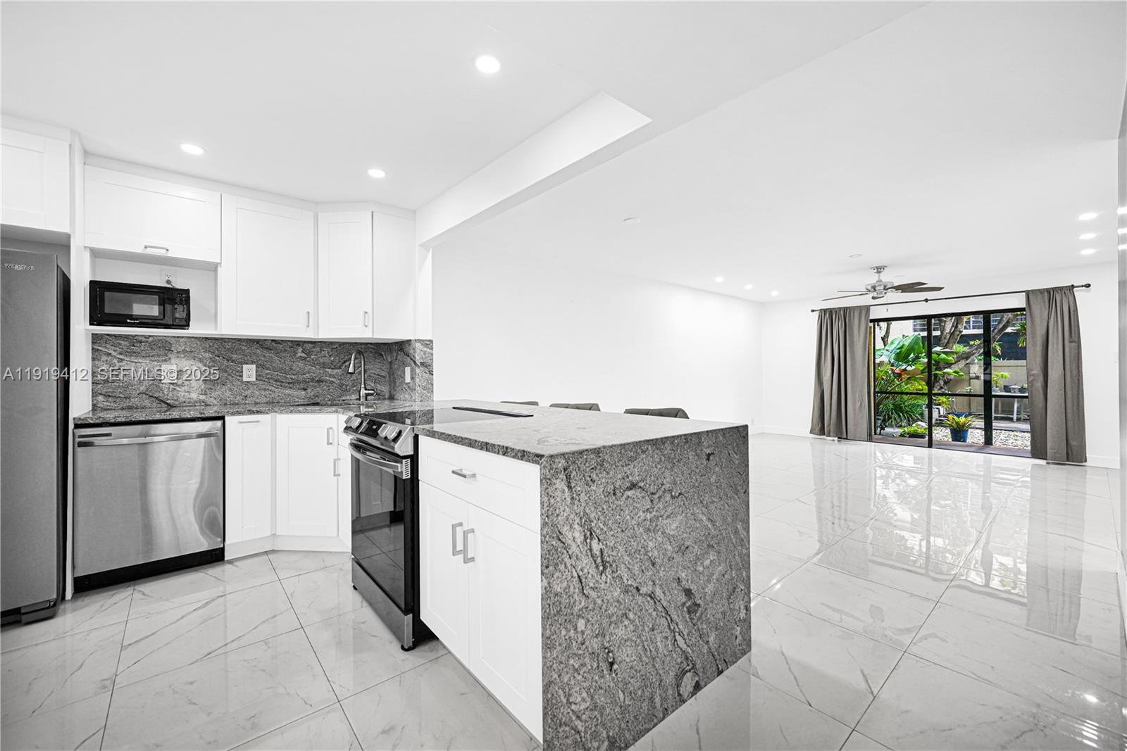 132 South Cypress Road, Unit 518 Pompano Beach, FL 33060 - Photo 7 of 60 a kitchen with stainless steel appliances granite countertop a stove a sink and a microwave