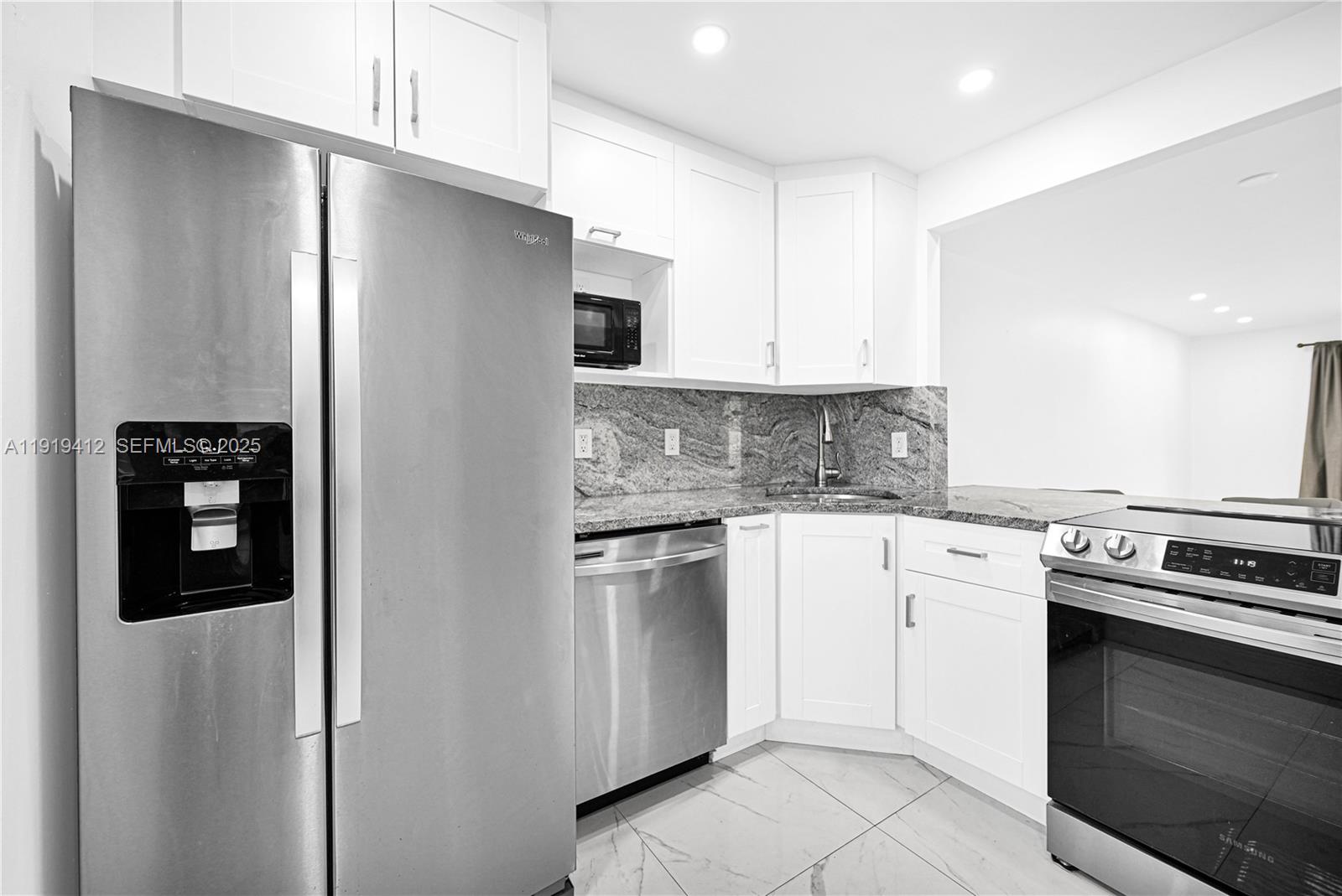 132 South Cypress Road, Unit 518 Pompano Beach, FL 33060 - Photo 10 of 60 a kitchen with stainless steel appliances granite countertop a refrigerator and a stove