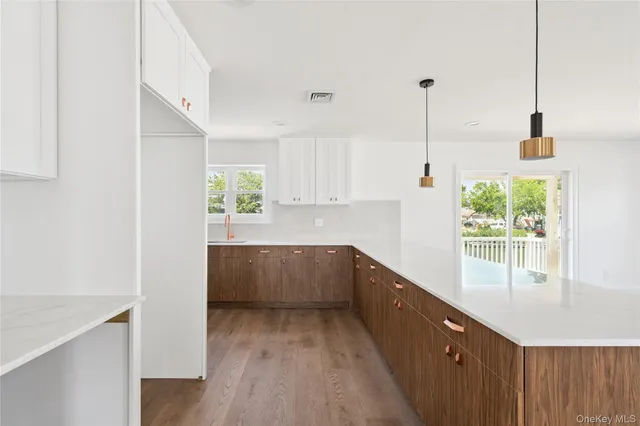 a kitchen with white cabinets and window