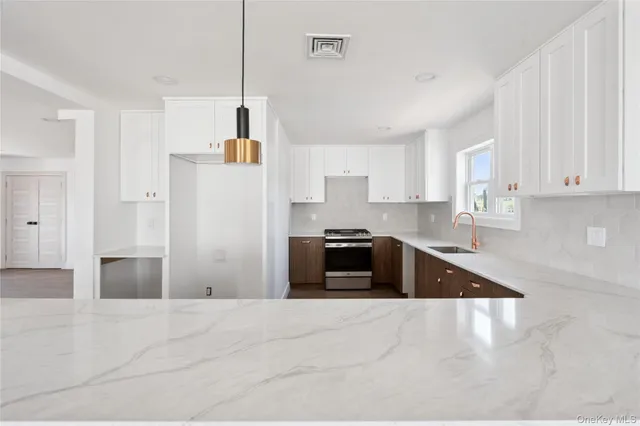 a kitchen with granite countertop a refrigerator and a stove top oven