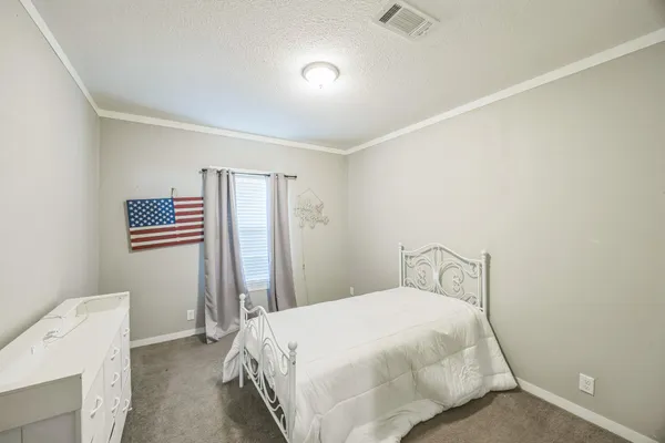 a bedroom with a bed and a refrigerator