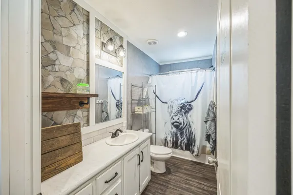 a bathroom with a sink a toilet and shower