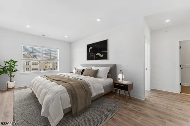 a bedroom with a bed a mirror and a flat screen tv