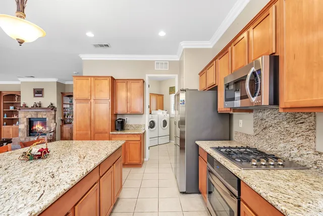 a kitchen with stainless steel appliances granite countertop a sink refrigerator and microwave